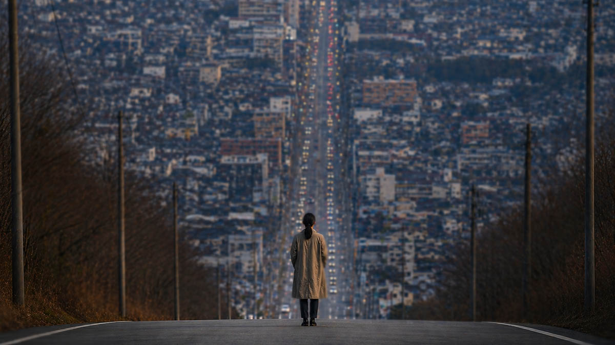 望遠で後退して撮影した都市風景。手前の人物と遠景の街が近く見える圧縮効果の例